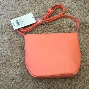 A New Day coral bag with adjustable strap zip top.